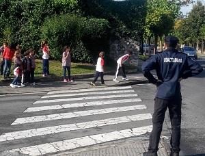Un agente observa a un grupo de nios al otro lado de paso de peatones