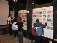 Un grupo de estudiantes observa los dibujos colgados en una pared