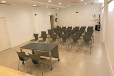 Una sala de conferencias con sillas en un lado y una mesa con dos sillas al otro
