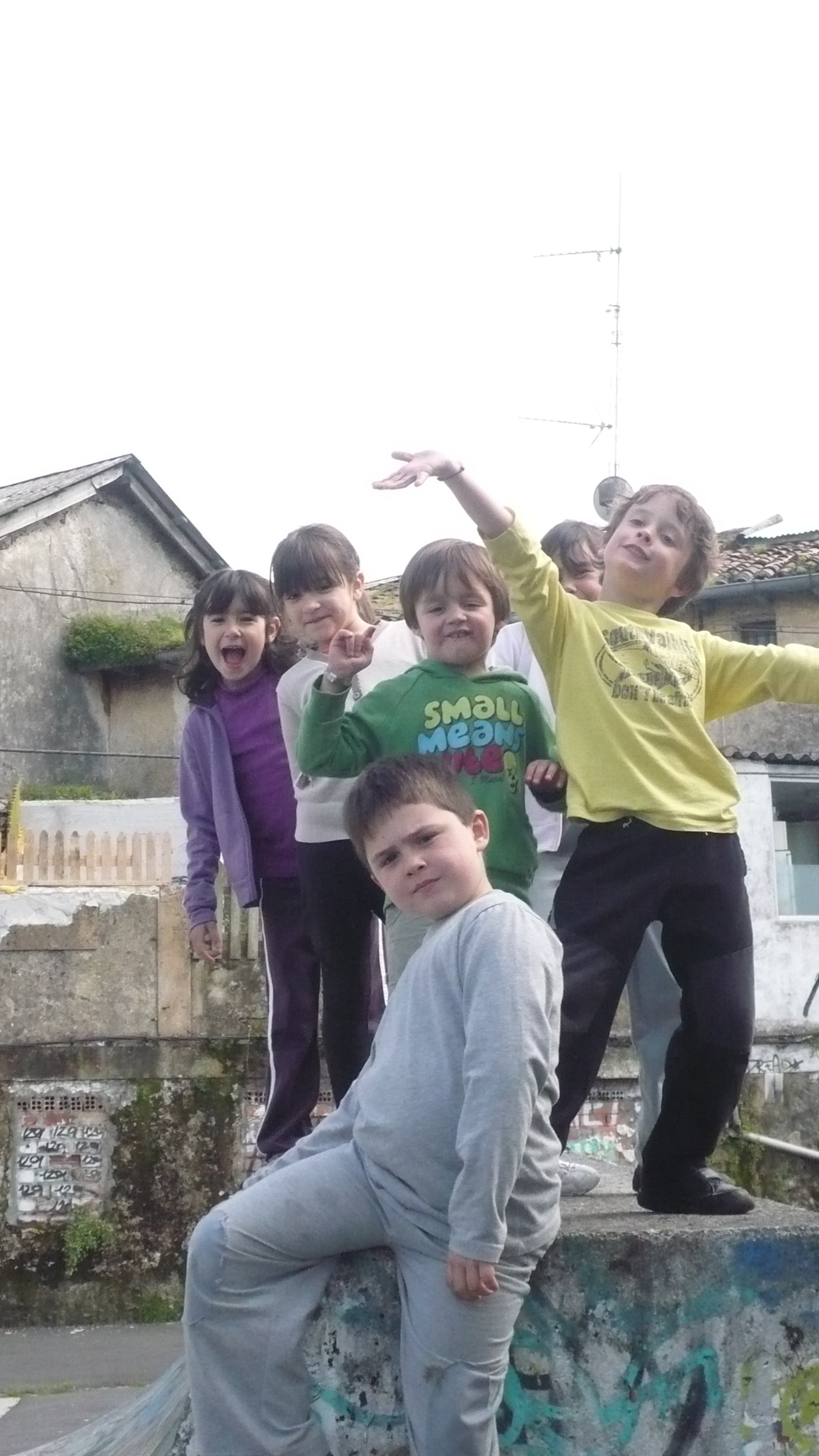 Seis niños y niñas posan en la plaza de un pueblo